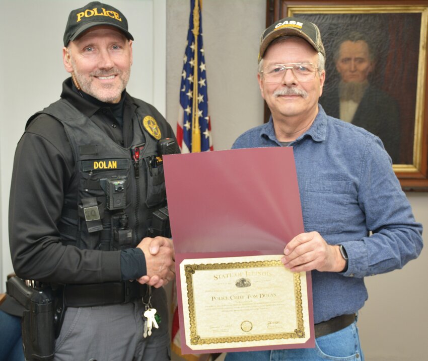 As one of his final acts as Chrisman Mayor Dan Owen, right, presented a special certificate from the Illinois legislature to Chrisman Police Chief Tom Dolan, left. The certificate obtained by Rep. Adam Niemerg (R-Dieterich) honors Dolan, who was injured in the line of duty while responding to a domestic incident.