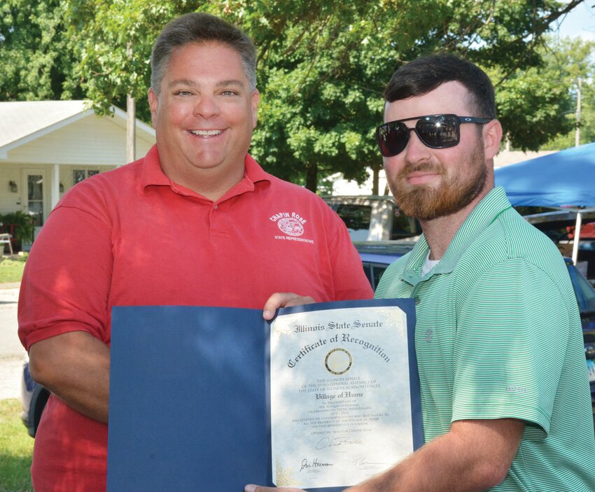 Senator Chapin Rose (R-Mahomet), left, presents an Illinois Senate Proclamation honoring the Village of Hume for its sesquicentennial. Village president Seth Eads, right, accepts the proclamation on behalf of the community.