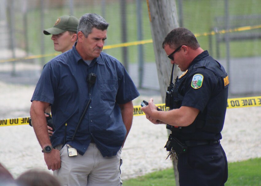 Paris Police Chief Terry Rogers (right) briefs a member of Illinois State Police Command Staff on Tuesday, August 15, following an incident near Carolyn Wenz School.