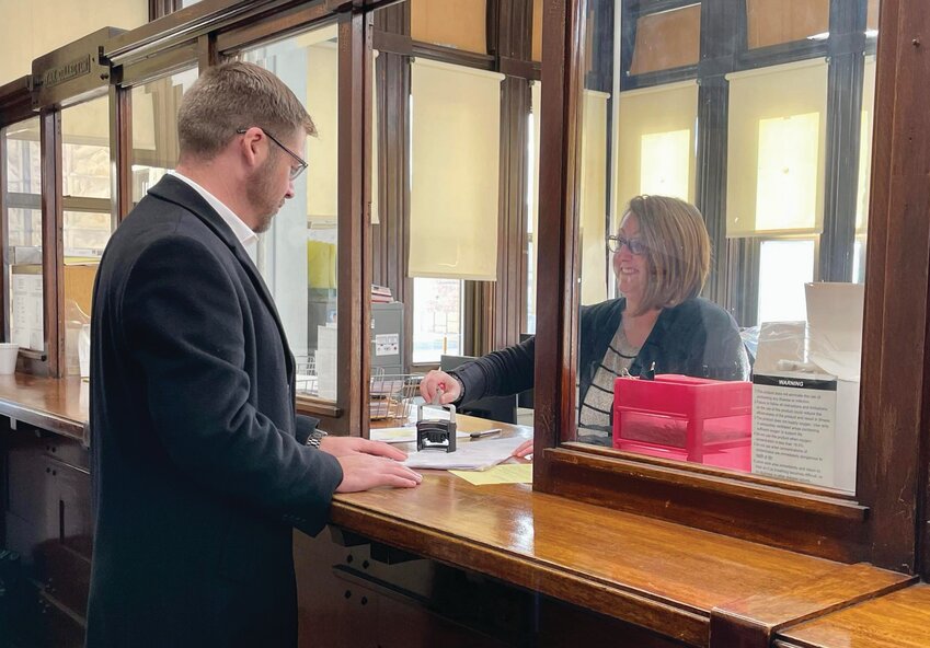 Current Edgar County Coroner Scott Barrett (left) fills out a petition to be included on the ballot for the upcoming primary election.