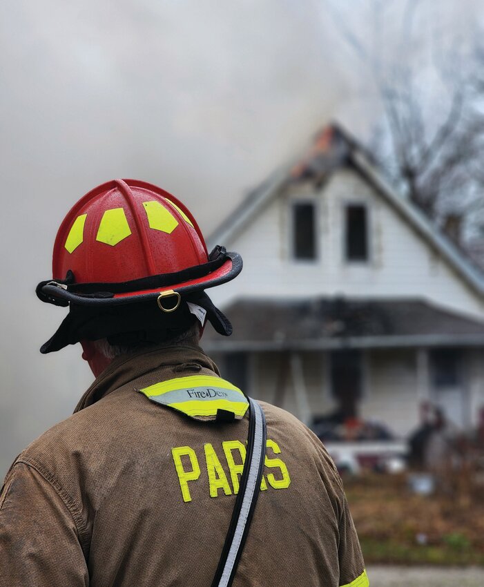 Captain Steve Gallagher of the Paris Police Department watches the brave members of the Paris Fire Department work to extinguish the flames of a house fire that sparked the morning of Jan. 1