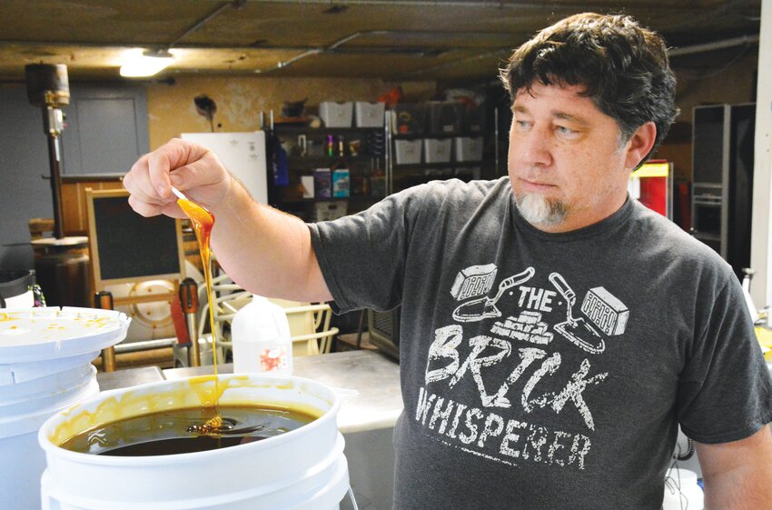 Kevin Tracy, pictured here analyzing a batch of honey, has been cultivating his craft for 28 years, most recently in the basement space of Lot 50, where he is producing a variety of  different meads.