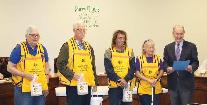 Paris Mayor Craig Smith (far right) reads a proclamation honoring the Lions Club for its work helping the visually and hearing-impaired population in both Edgar County and the state during a city council meeting Monday, April 8. The proclamation declared April 26 and 27 as  &ldquo;Tootsie Pop Days&rdquo; in Paris. Lions Club members will be at the intersections of Jasper and Main and Jasper and Central those days, selling Tootsie Pops to passing motorists.