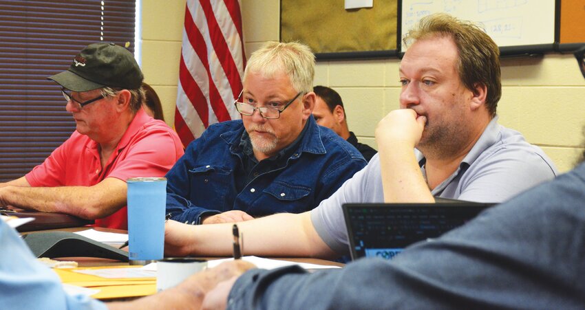 Edgar County Board members Andy Patrick (left), Russ Lawton (center) and Joshua Knight of the Edgar County Highway Department (right) take notes during the Thursday, April 25 bid opening.