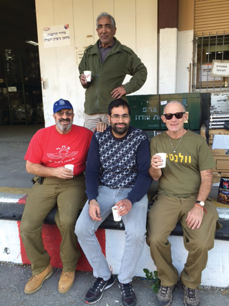 MEN DOING MITZVOT: From left, Ken Schneider, Ori (a boss on the base), Kevin Dwares and David (another boss) take a brief break from their work in Israel.