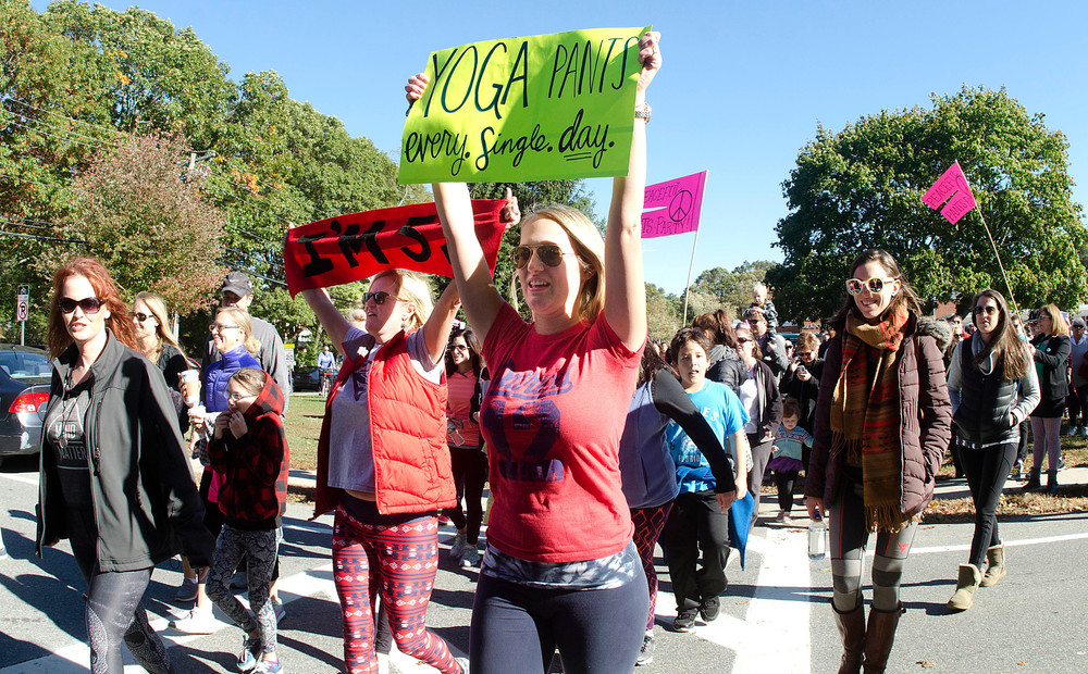 Cari Hogberg (middle) and her mom, Camila DiMarco (left) lead yoga pant wearing participants across New Meadow Rd during a demonstration on Sunday.