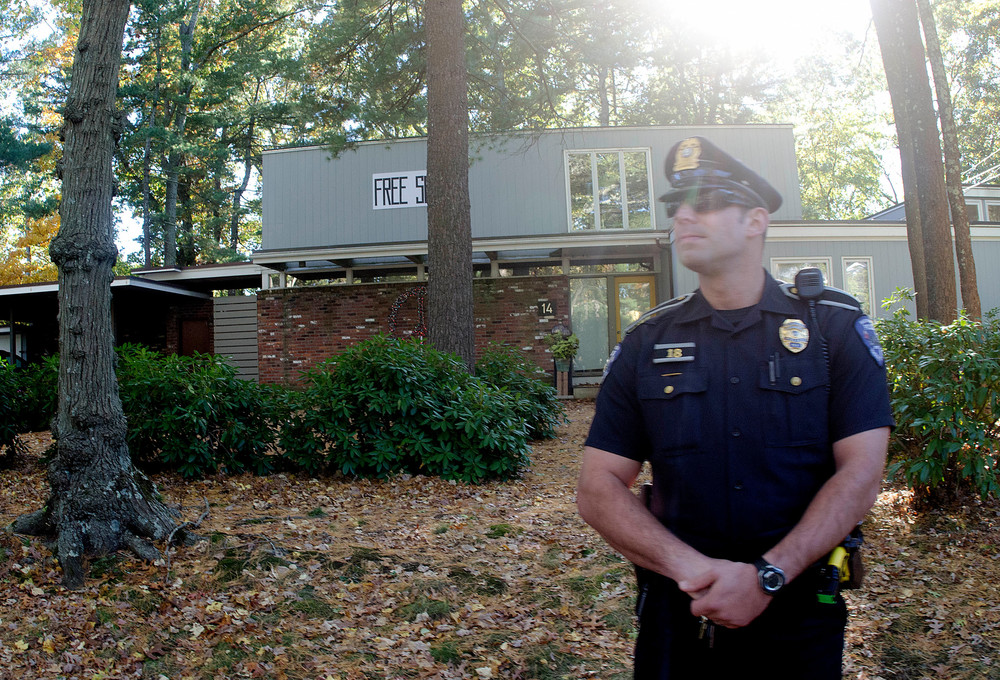 A Barrington police officer stands outside Mr. Sorrentino's home during Sunday's yoga pants parade.
