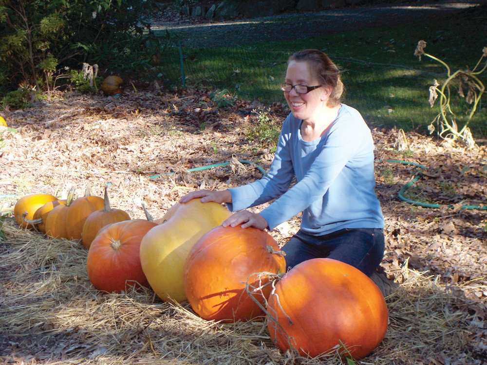 PLENTY OF PUMPKINS: Rhonda Shumaker, co-owner of the Rocky Point Farm, prepares some of the many pumpkins that were seen during the Pumpkin Walk which drew thousands of attendees.