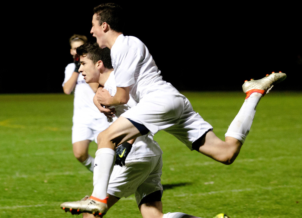 Nuno Amaralponte jumps on the back of Jeremy Lima in celebration after Lima scored the game winning goal for the Huskies on Tuesday night.