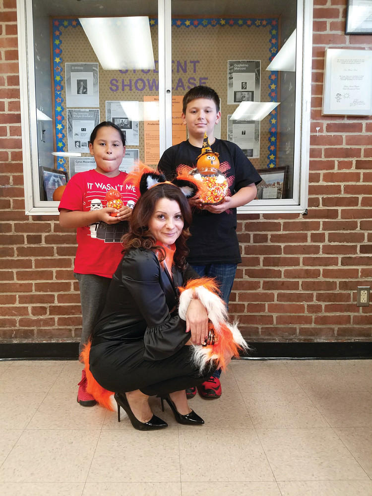 GOOD GUESSES: Kyleeh Iricanny and Ryan Audino, grades two and five, respectively, were the winners of the Candy Corn Count. Each came the closest to the actual amount of candy corn in the containers for their grade level, shown here, and received a prize. Both students are seen here posing with Principal Jill Souza, who is showing her Halloween spirit, dressed in her orange and black.