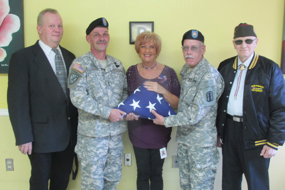 SERVICE STAFF: Lymansville VFW Post 10011 officials Tim Ross, Mike Oldrid, Mark McGrath and Jim Geyer flank Briarcliffe Manor Assistant Activities Director Corrine Elwell during Friday&rsquo;s special salute to veterans living at the Johnston facility.
