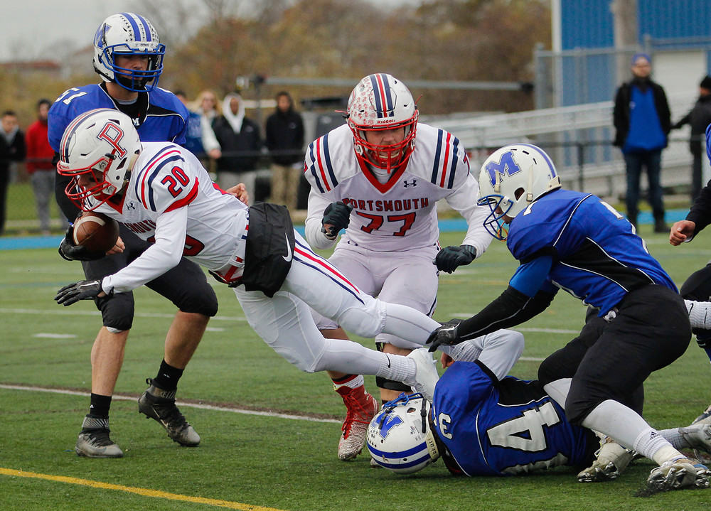 Senior Tim Murphy, who scored the Patriots&rsquo; final touchdown against the Islanders, is brought down by a Middletown defender. Tristan Krensavage (77) is in the middle.