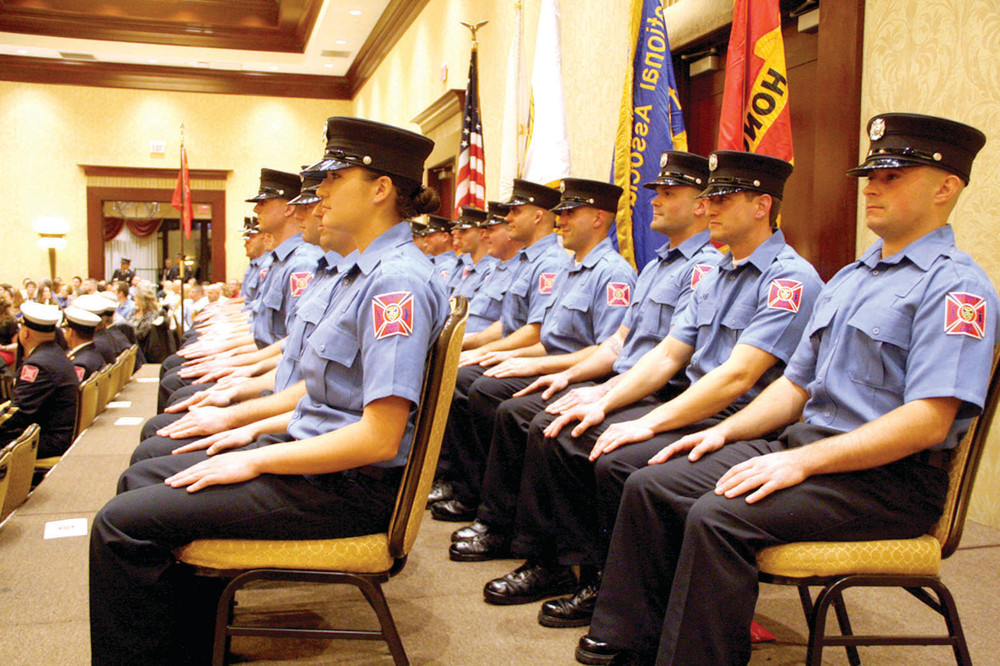 AT ATTENTION: Facing forward and sitting erect, 24 recruits wait to be given the oath of office.