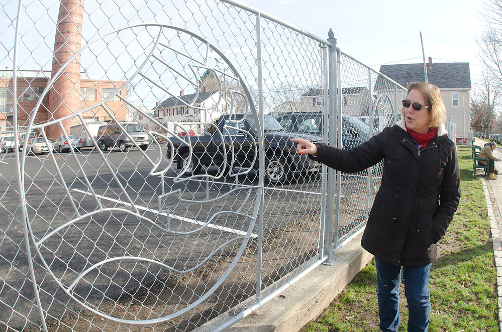 Mosaico Executive Director Diana Campbell shows the decorative fence that was recently erected along Wood Street. Medallions on the fence represent slices of life around Bristol.