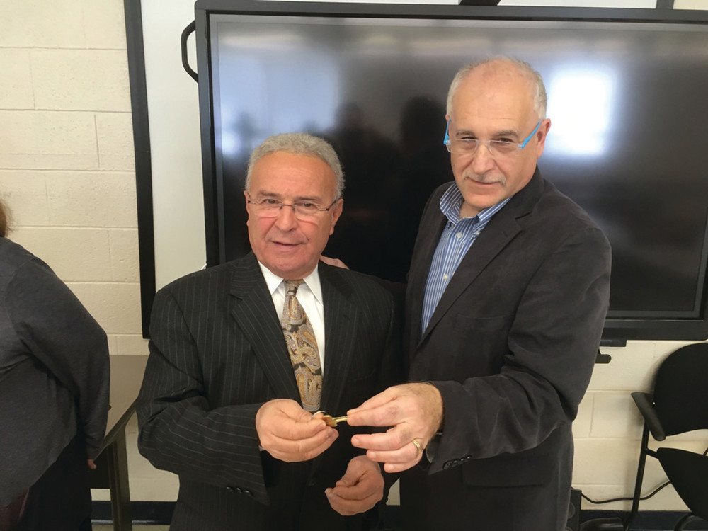 KEY EXCHANGE: North Providence Mayor Charles Lombardi accepts the keys for Calef Elementary School from Johnston Mayor Joseph Polisena after an accord was reached between the two communities.