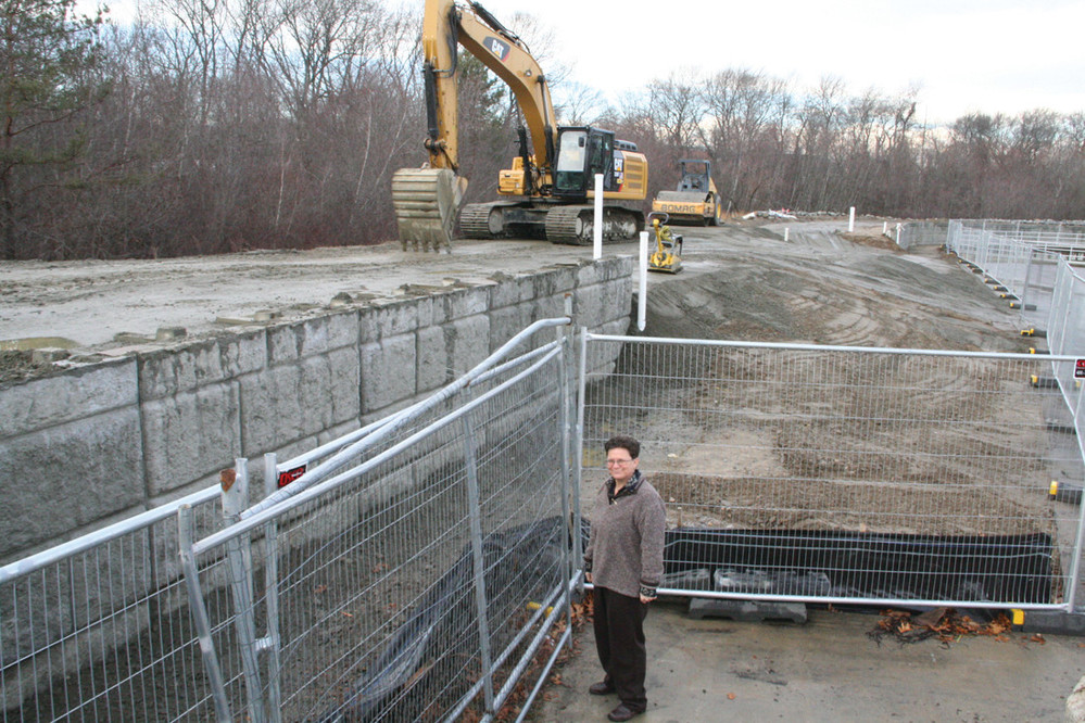 THE GREAT LEVEE: Janine Burke Wells stands at the foot of the levee being elevated another 5.5 feet at the Warwick Sewer Authority wastewater treatment plant.