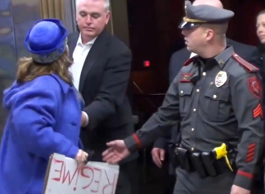 A screen shot from the video at golocalprov.com depicting the incident involving EPPD officers and a protester at a recent public meeting held by the state's Congressional delegation at East Providence High School.
