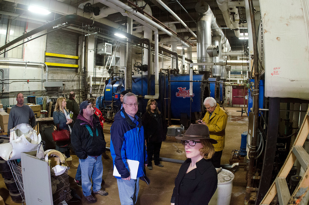 East Providence mayor James Briden (center) and finance director Lucy Maddock and members of the council and school committee take a long look around at the East Providence High School boiler room on Tuesday night during a walk through of the school.