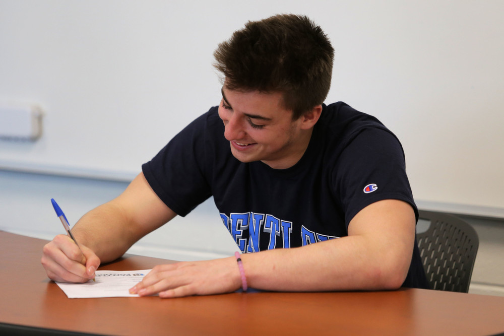 Portsmouth High senior Adam Parsons signs a commitment letter to play Division II football for Bentley University during a ceremony at the school last week.