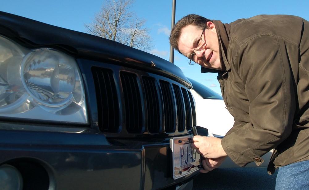He may play Santa Claus during the Christmas holiday season and serve as Bristol's Town Crier on other occasions, but Michael J. Rielly showed his versatility by putting on new Fourth of July license plates in the Mt. Hope High School parking lot.
