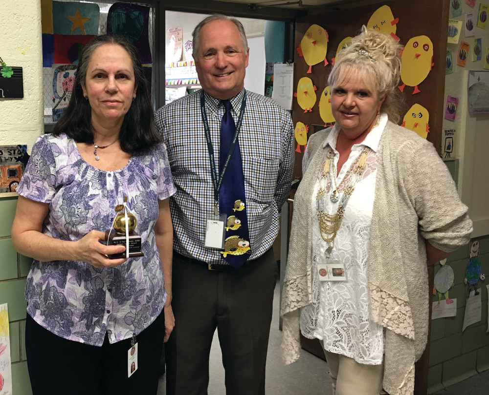 CORE COLLEAUGE: Francis Elementary teacher Sandra Tavitian, at left, received a Golden Apple Award from NBC 10, Hasbro, and the Rhode Island Department of Education for her outstanding teaching. Here, she stands outside her classroom with Francis Principal David Cluff and Secretary Debra Norman-Perry, who nominated her for the award.