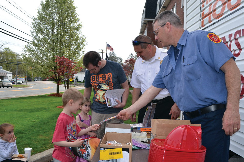 GREAT GIVEWAY: Eight-year-old Nolan and 4-year-old Katelyn Cahill joined their father Chris to pick up their new carbon monoxide detector. Johnston Battalion Chief Thomas Marcello and Firefighter Steve Veresko provided the kids with toy firefighter helmets and other treats.