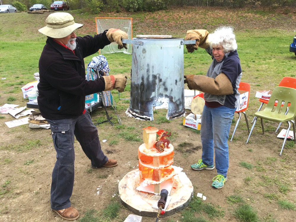 PIPING HOT: Artist Kate Champa needed assistance to lift the outer kiln cover to expose the still red hot student pieces of raku art.