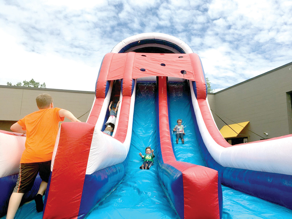 SLIP SLIDING AWAY: This giant inflatable slide was a huge hit with kids during My Cousin Vinny's Rentals grand opening on Sunday.