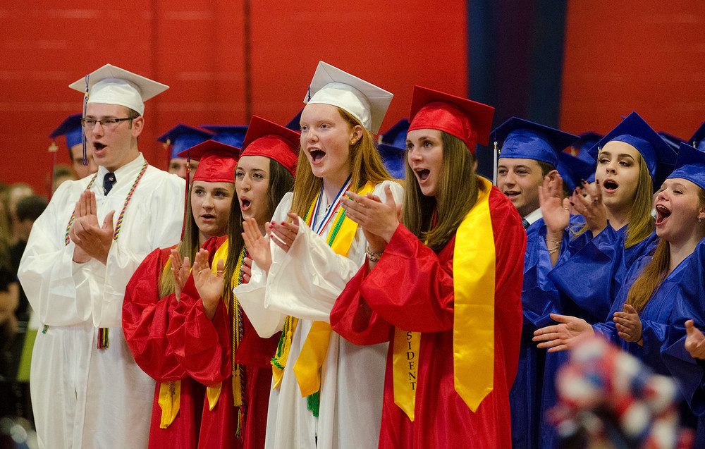 Mary Stack and Gabby DeComo (middle) cheer guest speaker Jean-Paul Arsenault during graduation exercises in the field house Friday evening.