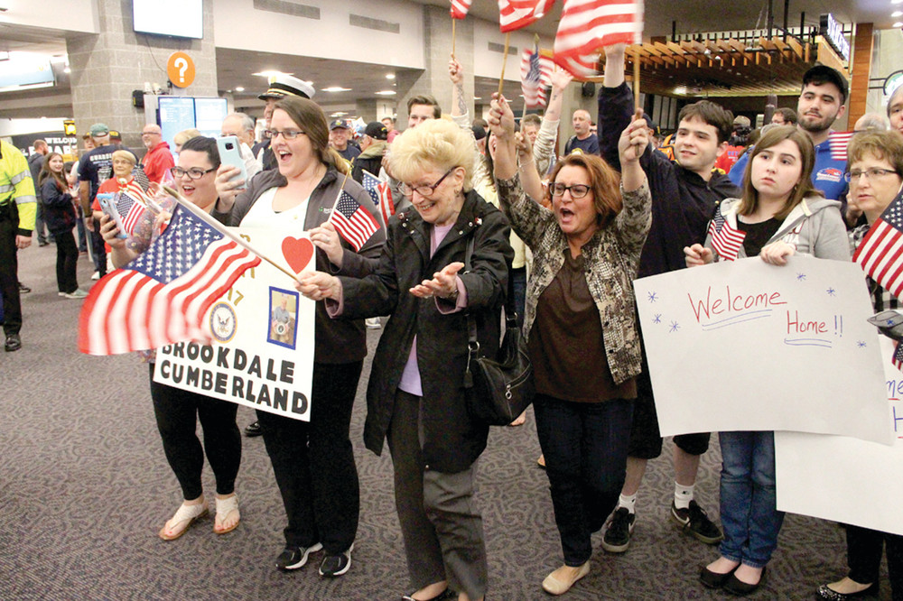 THEY&rsquo;RE BACK: Ann Botelho and her daughter Donna Zarrella in the foreground welcome home Korean War veteran and family member Gilbert Botelho upon his return from the Honor Flight Saturday to visit Washington DC.