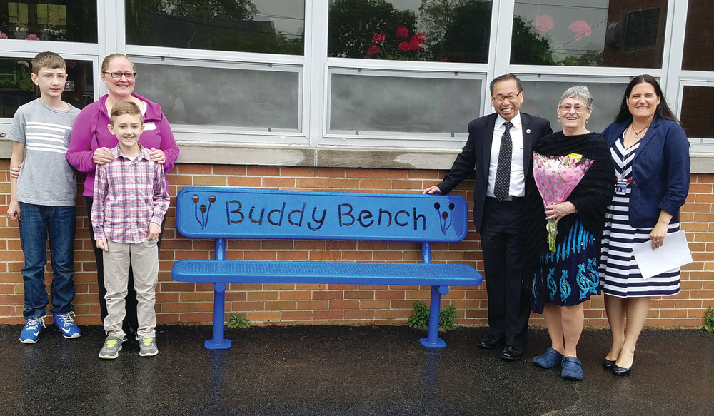 A SPECIAL SPOT FOR ALL TO ENJOY: King and her family pose with Principal Sevigny and Mayor Allan Fung by the new buddy bench, situated on the Eden Park recess grounds.