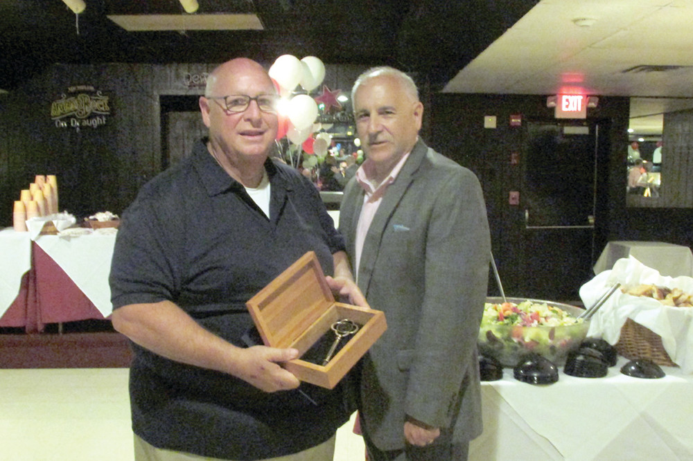 GRAND GIFT: Rev. Peter J. Gower, pastor at Our Lady of Grace Church, receives a special surprise - a key to Johnston - from Mayor Joseph Polisena during last Friday night&rsquo;s 60th birthday bash at Silvio&rsquo;s Restaurant.