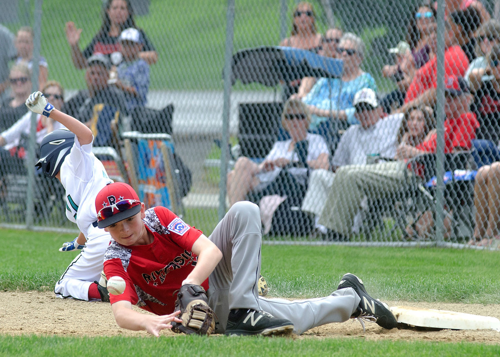 Tyler Johnson briefly hangs on to a throw by Ethan Martins after he fielded a bunt, long enough to record an out. Johnson bobbled the ball after the play according to umpires, during Riverside's first game against Cranston Western.