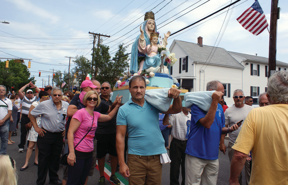 FIRST TIME FOR EVERYTHING: On the left, 1-year-old Sienna Troia leans in with dad David to touch the statue of the Madonna at the St. Mary&rsquo;s Feast Parade on Sunday. Mom Jessica joined them, as it was Sienna&rsquo;s first-ever St. Mary&rsquo;s Feast.