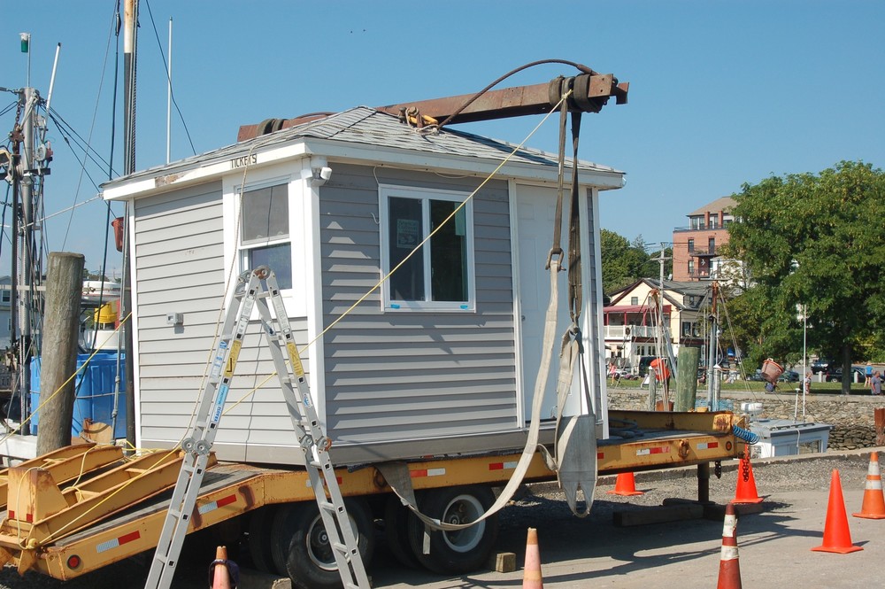 A contractor working on the Prudence Ferry dock was rushed to the hospital after he was thrown from a bucket truck while attempting to lift this ticket booth into place.
