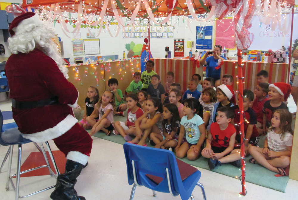 SPECIAL REQUESTS: Santa Claus sits on a chair and fields a variety of special requests from children who attended the unique Summer Explore program.