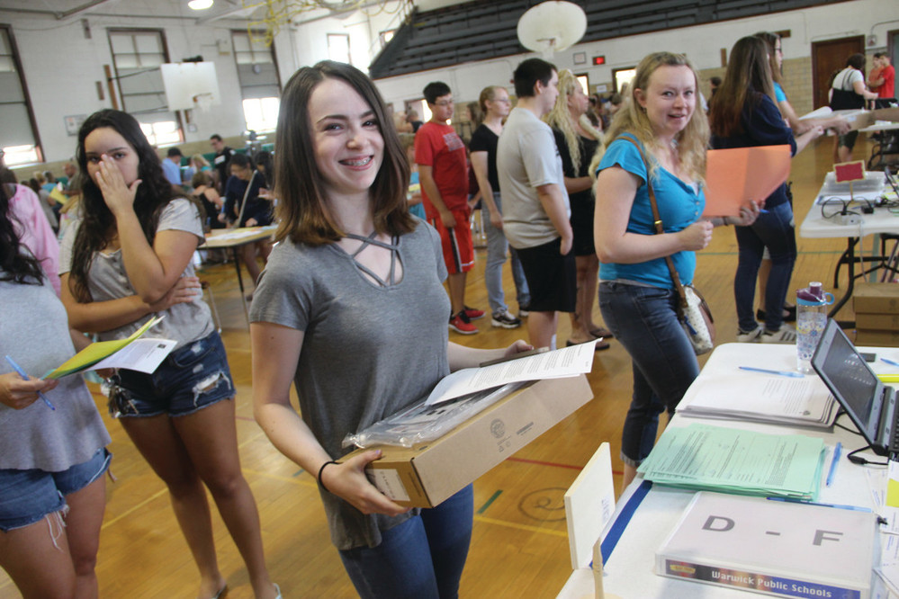 LONG LINES BUT ALL&rsquo;S FINE: Isabella DeMelo, about to begin the school year at Pilgrim High School, with her new Chromebook during the busiest rush of Saturday&rsquo;s Chromebook Carnival event at the Gorton Administrative Building gymnasium.