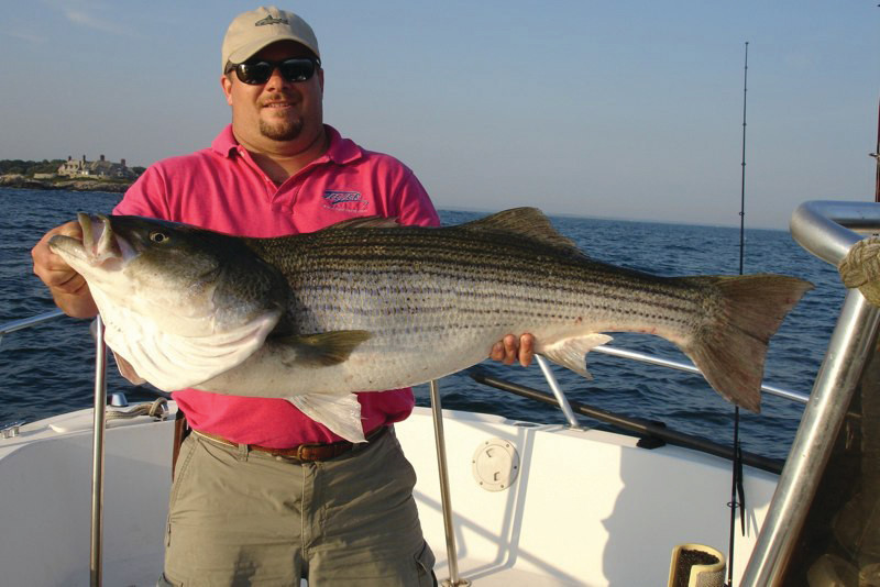 REELING THEM IN: Capt. Eric Thomas of Teezer Fishing Charters with a 40-pound Newport shoreline striped bass he caught 'fishing the wash.&rsquo;