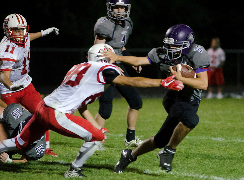 Huskies quarterback Matt DeFelice (middle) looks on as running back Dylan Martins holds off a Townies tackler for a short gain in their game at Mt. Hope High School on Friday night. Martins scored a touchdown during the game.