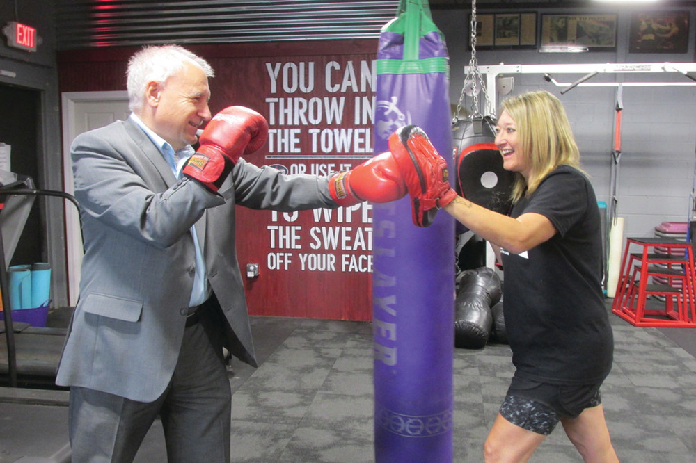 POWER PUNCH: Johnston Mayor Joseph Polisena tests his mettle during a fun-filled exchange with Christina Rondeau, the popular owner-operator of Rondeau&rsquo;s Kickboxing and Fitness that has moved to 609 Killingly Street and held its Grand Opening Saturday.