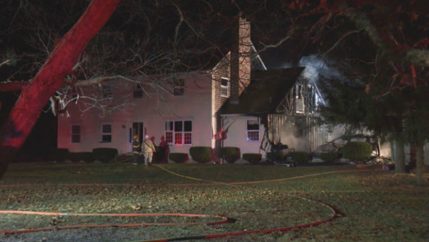 Firefighters hose down the smoldering garage early Thursday morning. The main house was saved. Photo by WPRI TV12.