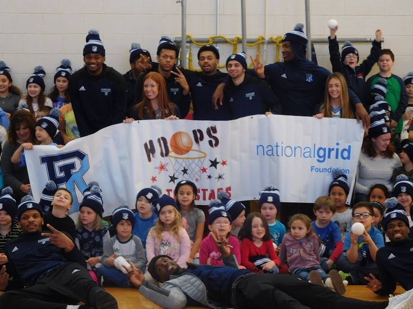 URI team members (that&rsquo;s Stanford Robinson lying across the foreground) and cheerleaders pose for a group shot and a &lsquo;Let&rsquo;s Go Rhody&rsquo;  chant with their Pocasset School fans.