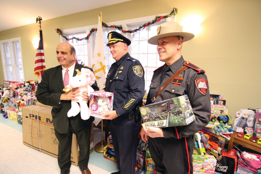 NO TOYING AROUND: Mayor Joseph Solomon, Police Chief Col. Rich Rathbun and State Police Col. James Manni join for a photo at the &ldquo;Kids, Cops and Christmas&rdquo; event Tuesday at Buttonwoods Community Center.