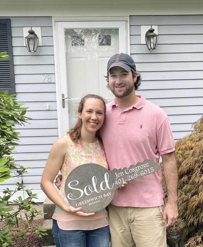 First-time home buyers Jeremy and  Rebecca stand   in front of   their first home