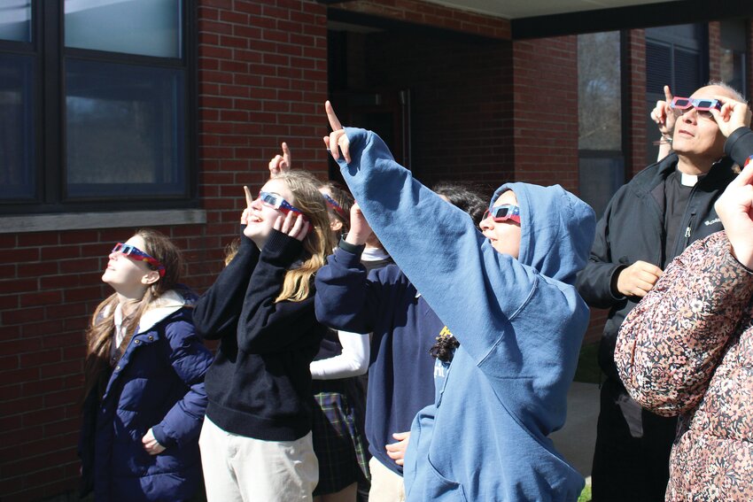 Students from All Saints STEAM Academy in Middletown marvel at the sight of the rare eclipse through their solar safe glasses.