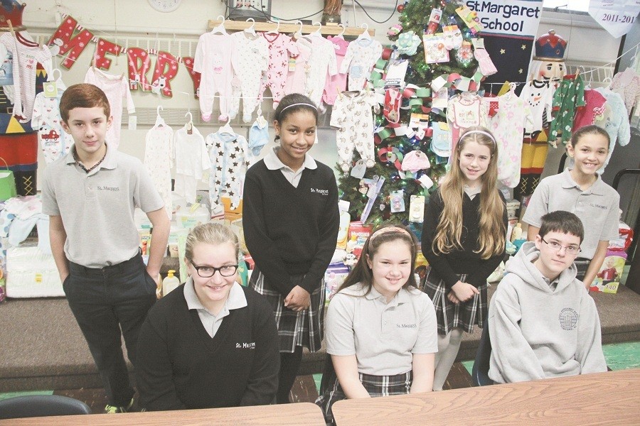 SHOWERING OF SUPPORT: Seventh-graders at St. Margaret School, East Providence, led a drive to assist the diocesan Human Life Guild&rsquo;s Gabriel Project, which assists families in need with supplies for their young children. The students collected more than 100 items of clothing and supplies, including sleepers, hats, booties, blankets and diapers. Representing the seventh grade class, from left, are Joe Ferreira, Emma Laliberte, Andrea Santos, Michelle Kazakov, Rose Callahan, Nathan Hickey and Jade Cepeda. During this Year of Faith, Catholics are called to reach out to each other through generous acts of kindness and support. The faithful are called to inspire and bring each other to a new conversion to the Lord.