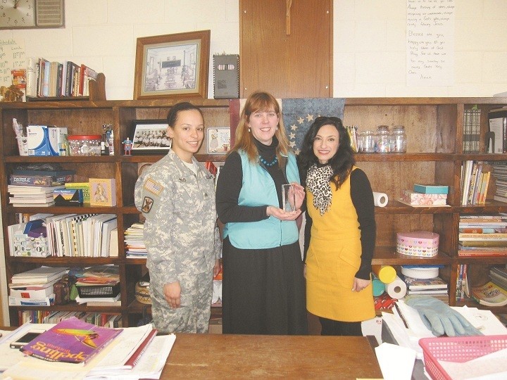 FAITH AND SERVICE: Sgt. Diana Jimos, left, and Lori Hart, right a Yellow Ribbon Specialist with the Rhode Island Air National Guard, present Collette Maynard, a grade 6 teacher at Father John V. Doyle School, Coventry with the Minuteman Award in appreciation for her service to the National Guard. Maynard has routinely enlisted the help of her middle school students to prepare cards, letters and other special acknowledgements to show support for members of the Guard as they serve their country. The Minuteman Award recognizes exceptional achievement, a patriotic act, highly distinguished service or an outstanding contribution to a military organization, community, state, nation, as well as to the National Guard Association. During the Year of Faith, Catholics are reminded of their call to prayer and service and are encouraged to help others live their lives with faith, hope and love.