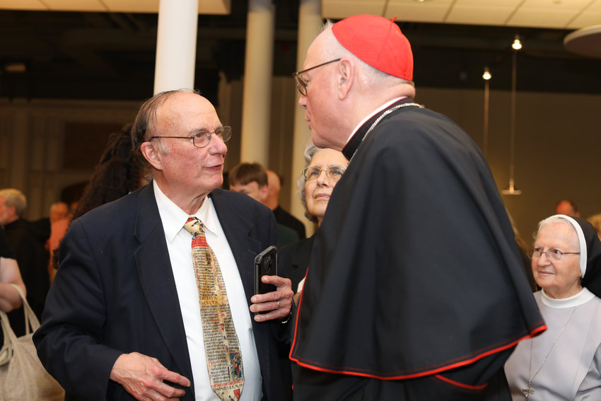 Richard Dujardin, longtime religion reporter for The Providence Journal, accompanied by his wife Rose-Marie, speaks with Cardinal Timothy M. Dolan, Archbishop of New York, during the Cardinal&rsquo;s special presentation at the Cathedral of Saints Peter and Paul as part of the Diocese of Providence&rsquo;s 150th anniversary celebration on Sunday, May 15. Dujardin, 77, died in a fall on Aug. 15 in Milwaukee.