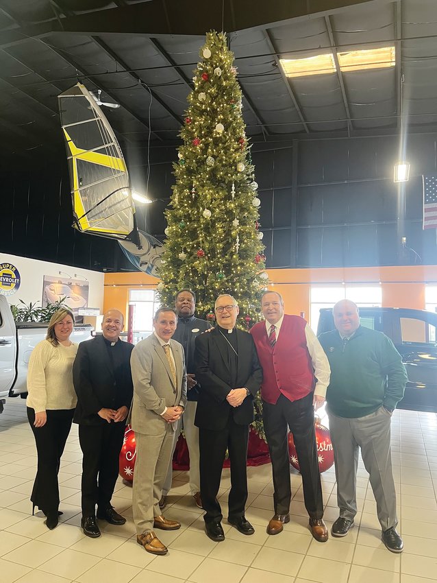 Bishop Thomas J. Tobin visits Paul Masse Chevrolet in East Providence on Dec. 6, to receive a generous donation from the Masse family and company to help &lsquo;Keep the Heat On&rsquo; and to assist many other ministries in the Diocese of Providence through the Catholic Charity Appeal and the Diocesan Assistance Fund. Pictured from left, Office Manager Kelly Gaulin, Pastor of St. Thomas More Church Father Marcel Taillon, President Scott Wellington, BDC Representative Farris Maxwell, Bishop Thomas J. Tobin, Founder and Chairman Paul Masse, and Vice President Bob Masse.