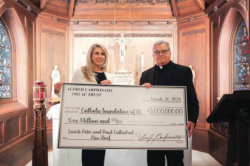 Sheryl Carpionato presents Cathedral of SS. Peter and Paul Rector Msgr. Anthony Mancini with a check for $1 million on March 20, carrying out her late husband&rsquo;s wishes to help restore the cathedral&rsquo;s slate roof, which was replaced in 2020 for $4.5 million.